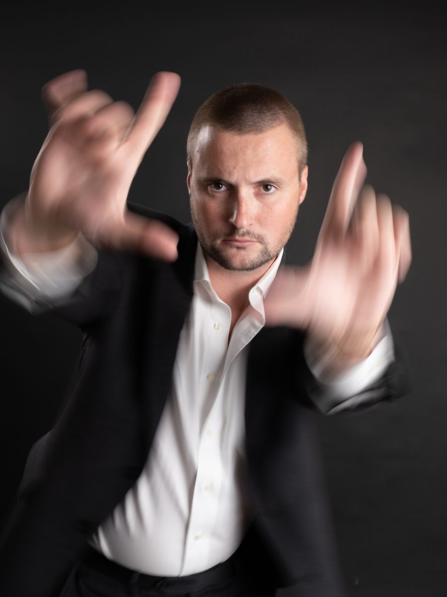 Creative portrait of a man in a suit framing the camera with his hands