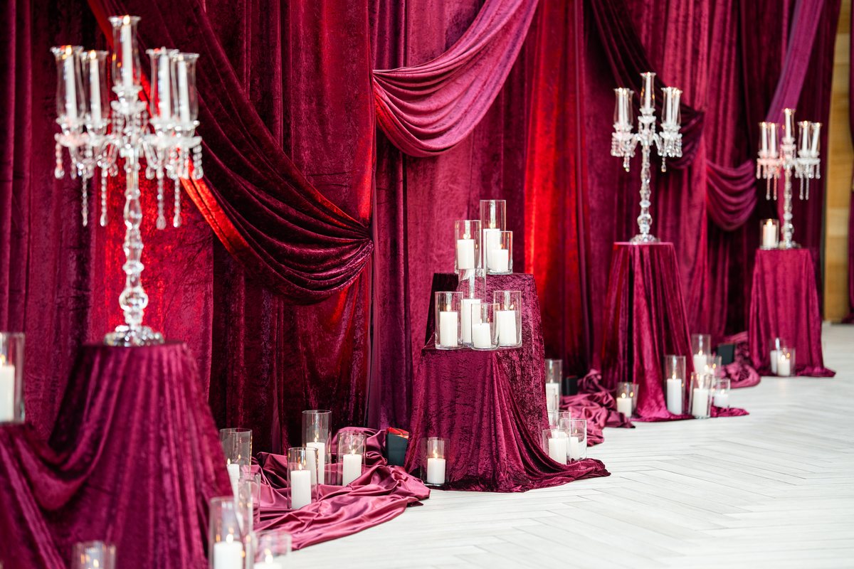 Crystal candelabras and pillar candles against red velvet drapes