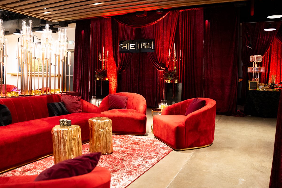 A red velvet lounge with gold accents and crystal candelabras at the HEI welcome reception