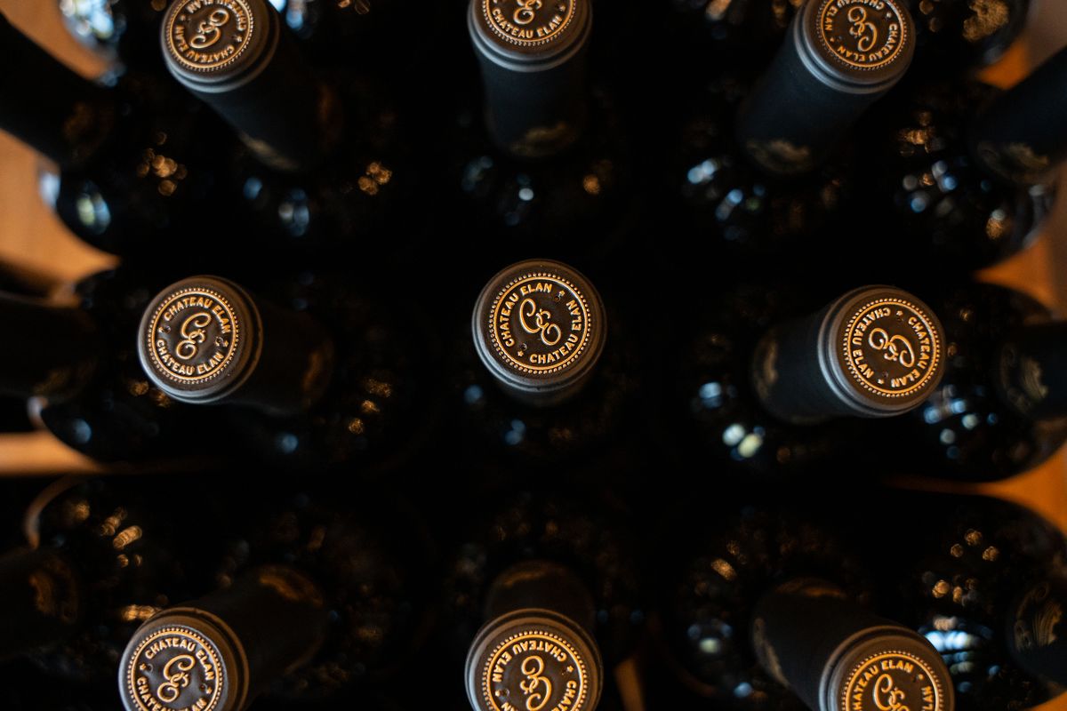 Overhead view of rows of wine bottle tops with embossed foil caps