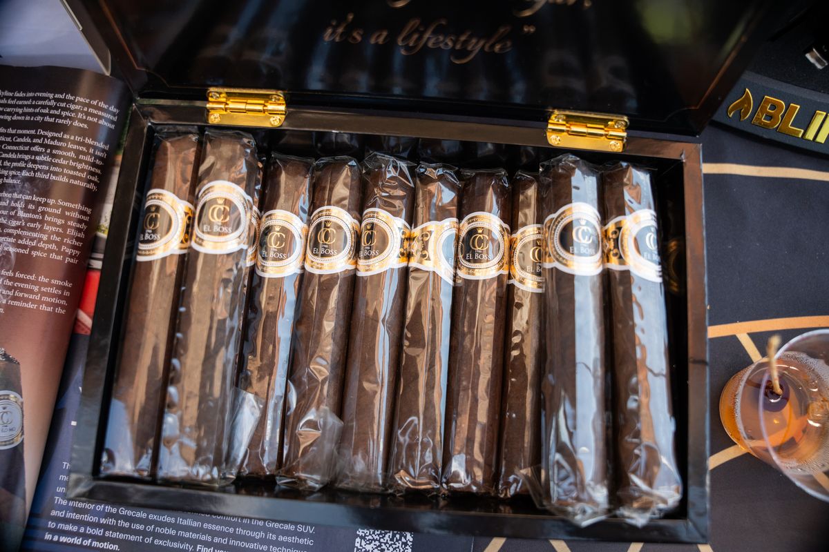 A box of premium cigars with gold bands